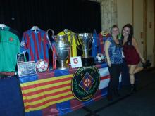 PBL girls posing in front of the FCB exhibition and the Champions League and La Liga cups